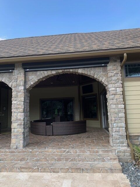 Motorized screens on a stone-arched lanai